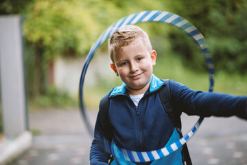 Cute Caucasian blond boy spinning a hula ring