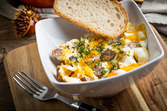 Scrambled eggs with sausage and bread.