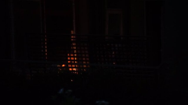 Night shot showing a grille outside an apartment home being welded suddenly giving light to all surroundings