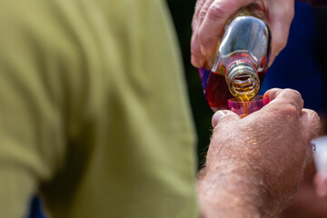 Pouring homemade whisky as folk tradition when you reach mountain top.