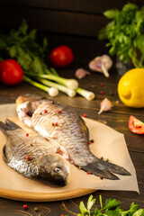 Fresh carassius on the board, river fish crucian carp with spices ready for frying or roasting in the oven