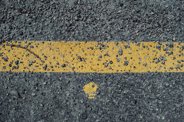 Texture of asphalt and yellow road markings, line and dot, close up