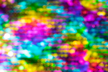 Multicolored abstract shiny background with bokeh, defocused Christmas lights. Festive concept. Selective focus.