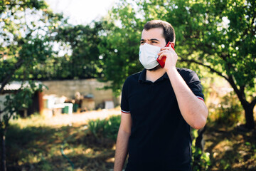 Teenager or young man Talking on the mobile phone with mask in the village