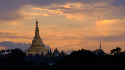 The stunning Shwedagon pagoda in Yangon, Myanmar. A stunning red filling the sky around this exciting building.