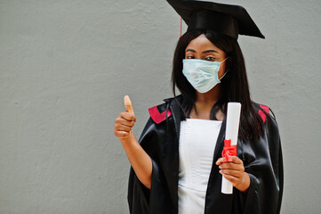 Young female african american graduate student wears a protective mask against coronavirus. Concept...