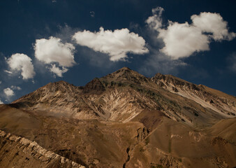 Magical view of the rocky mountain peak under beautiful clouds. 
