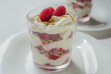 Traditional Scottish Cranachan dessert with toasted oats, fresh raspberries, cream and whisky in a glass.