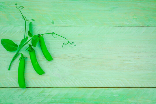 Fresh green pease from the garden on a wooden background