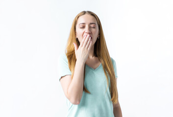 Tired girl on a white background yawning covers her mouth with her palm