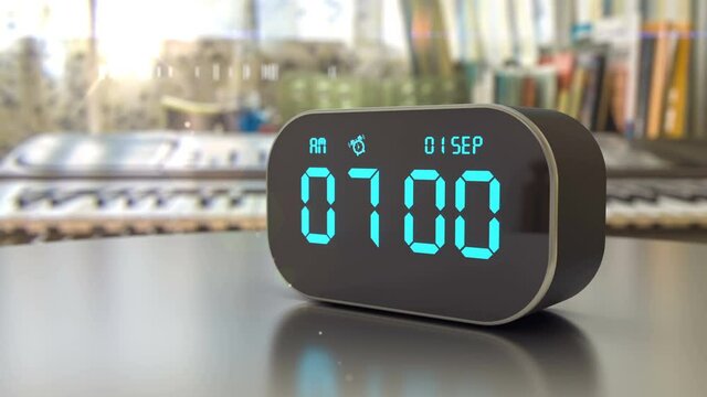 Alarm clock on the desk awakening the student to back to school. Today is 1st september and school children starts new educational year. Timer rings at 7 am and the sun is shining outside the window.