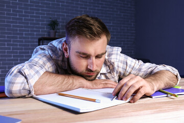 Student sleeping at table late in evening