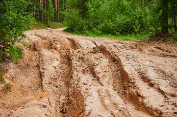 Dirty blurry dirt road with tire tracks in spring. Off-road.