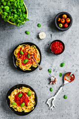 Tagliatelle pasta with arrabbiata sauce, basil, garlic, cherry tomatos, overhead flat lay shot