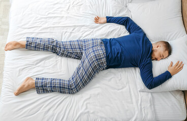 Young man sleeping in bed at home