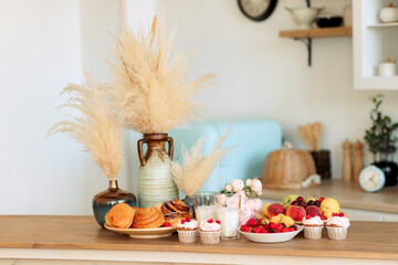 Breakfast at home. still life of dried flowers, fruits, berries, pastries and cakes on the kitchen table. Light, gentle, summer, autumn composition.