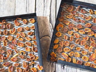 Procurement of dried apricots for future use. Dried apricots in a rack from the dryer on a wooden...