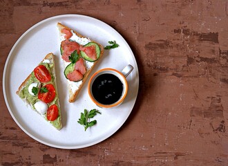 Light breakfast, assorted toasts with a variety of fillings on a white plate.