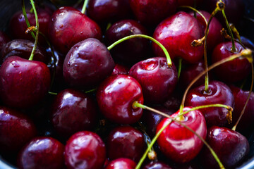 Red ripe cherries with twigs in a Cup and on the table