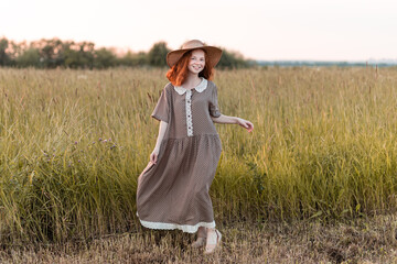 redhead model posing in a meadow at sunset