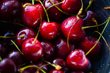 Red ripe cherries with twigs in a Cup and on the table