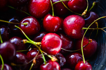 Red ripe cherries with twigs in a Cup and on the table