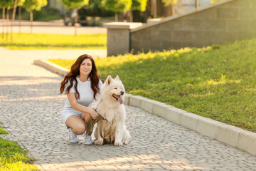 Young woman with cute dog walking in park