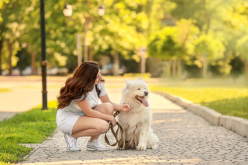 Young woman with cute dog walking in park
