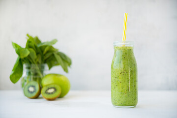 Fresh vegetarian smoothie drink in a glass bottle of green fruits and vegetables. Copy of space