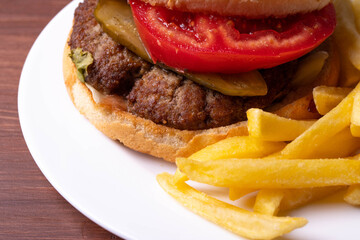 traditional fat burger and french fries on beige textile cloth