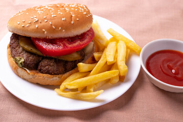 traditional fat burger and french fries on beige textile cloth