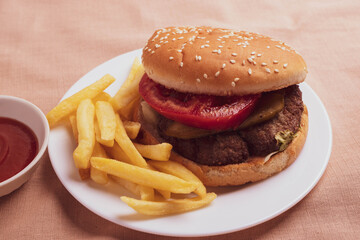 traditional fat burger and french fries on beige textile cloth