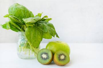 Fresh green fruit on a white background, Apple, kiwi and spinach. The concept of natural green nutrition.