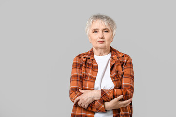 Stylish senior woman on grey background