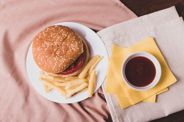 traditional fat burger and french fries on beige textile cloth
