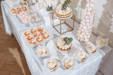 Candy bar at the banquet. Wedding table with sweets, cake, pastries, muffins, sugar treats. Event in the restaurant