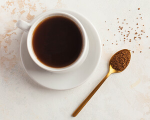 Instant coffee in a Golden spoon and a mug of black coffee. Concept of instant coffee birthday...