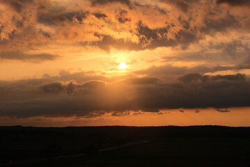 Late orange sunset over the field and road