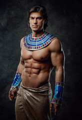 Fototapeta na wymiar Athletic man in ancient egyptian costume posing in the studio