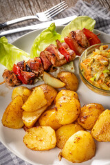Shish kebab served with roasted potatoes and salad.