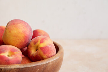 Bowl with ripe peaches on table