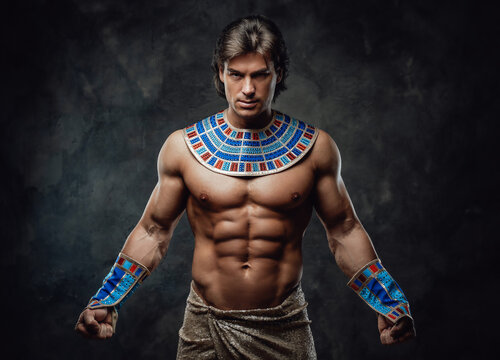 Athletic man in ancient egyptian costume posing in the studio with his fists clenched