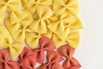Colored bow tie pasta. Closeup multiple farfalle isolated on white background.