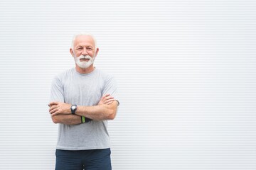 Portrait of senior sportsman standing with arms crossed