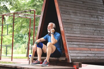 Senior sportsman talking on mobile phone at park