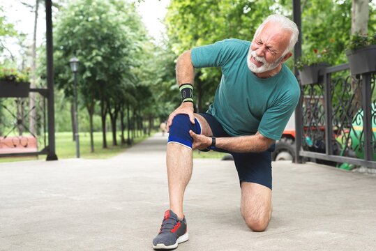 Senior man suffering with knee pain during workout