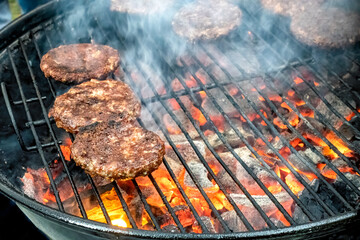 Juicy meat steaks cooked over charcoal on a wire rack. Meat cooked on a fire in the open air. Close-up.