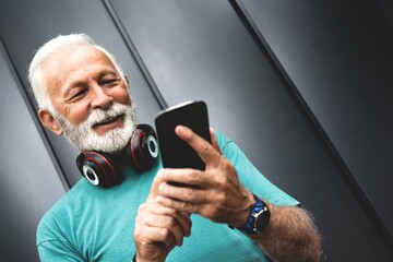 Senior sportsman using fitness tracking app on mobile phone