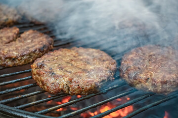 Juicy meat steaks cooked over charcoal on a wire rack. Meat cooked on a fire in the open air. Close-up.