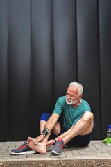 Senior man suffering with ankle pain during workout